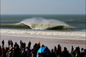 a group of people on a beach with a crowd watching